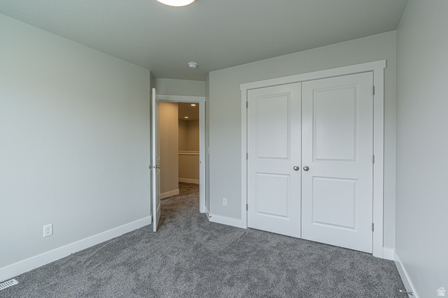 2249 South 1090 West, Unit 76 Nibley, UT 84321 - Photo 12 of 19 Neutral wall color, plush grey carpeting, white baseboards, white paneled double closet doors, and a white interior door frame
