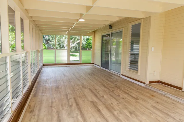 a view of a porch with wooden floor and garden