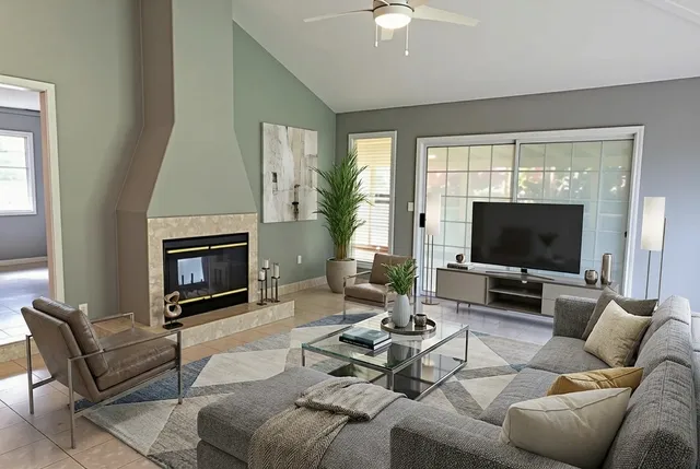 a living room with furniture a flat screen tv and a fireplace