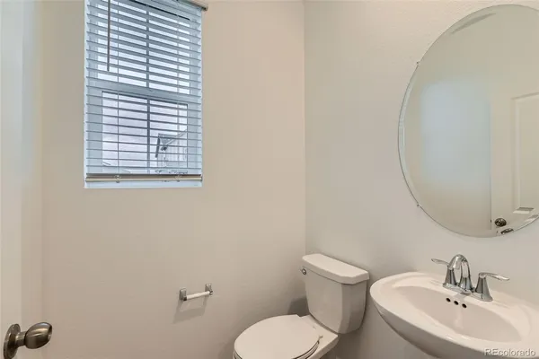 a bathroom with a toilet a sink and mirror