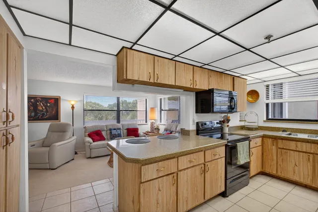 a dining room with furniture a chandelier and kitchen view