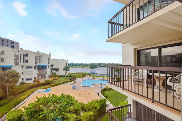 a view of a swimming pool with couches chairs and a fire pit