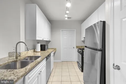 a kitchen with stainless steel appliances granite countertop a refrigerator and a sink