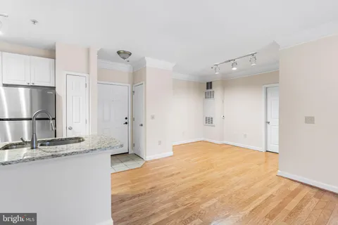 a view of empty room with wooden floor and window