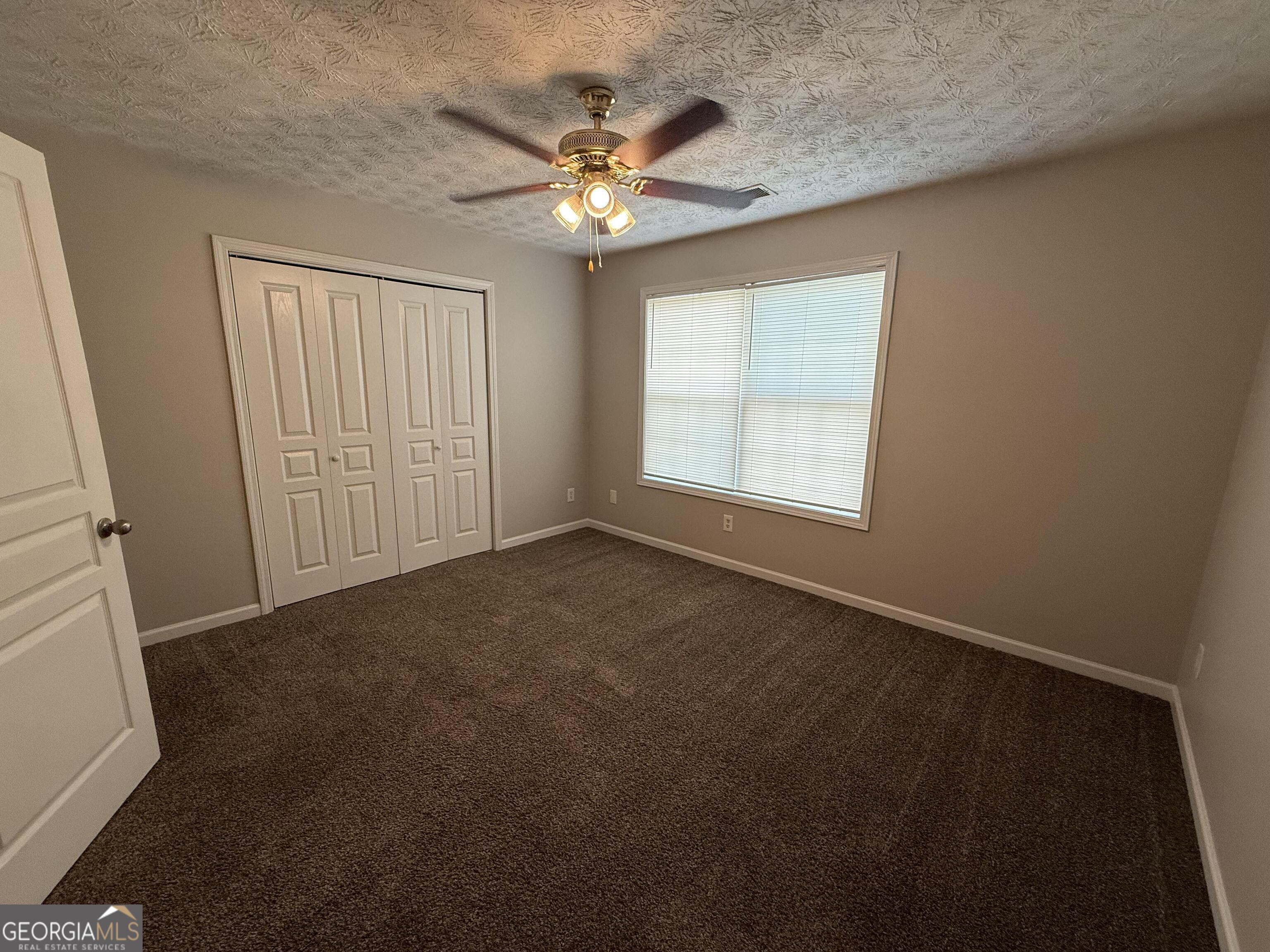 6132 Ruth Street Southwest Covington, GA 30014 - Photo 25 of 33 an empty room with windows and chandelier fan