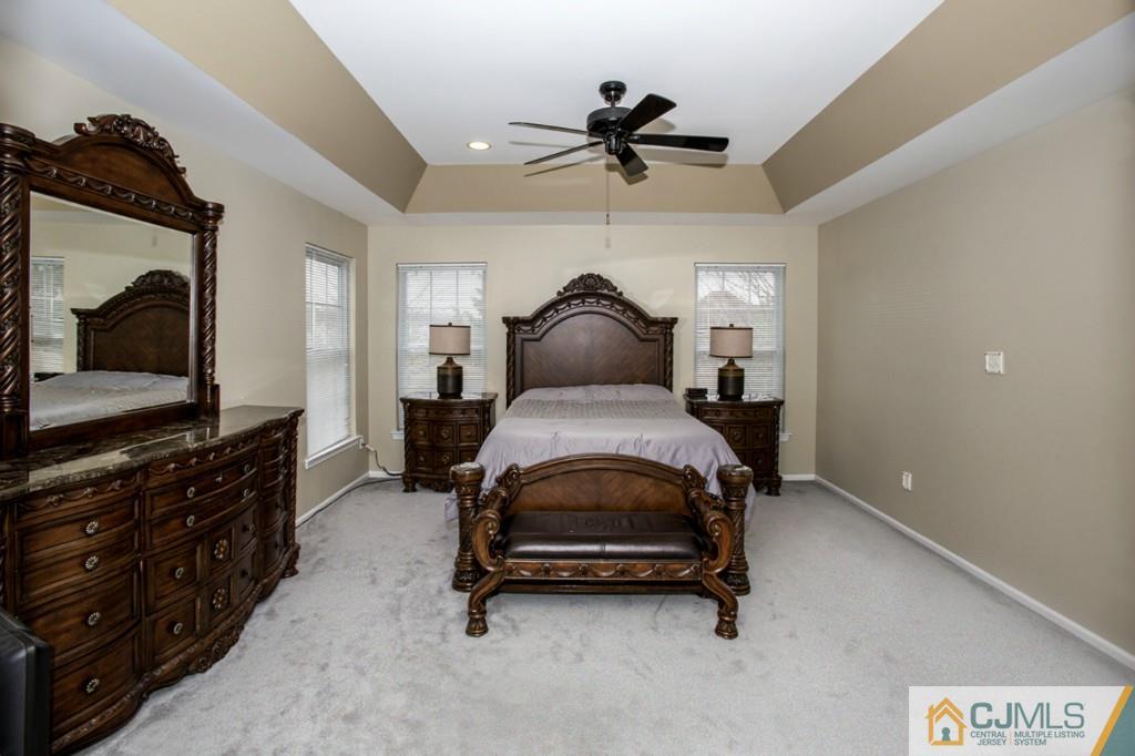 27 Timber Ridge Road North Brunswick, NJ 08902 - Photo 13 of 25 a bedroom with a bed and a flat tv screen on the dresser