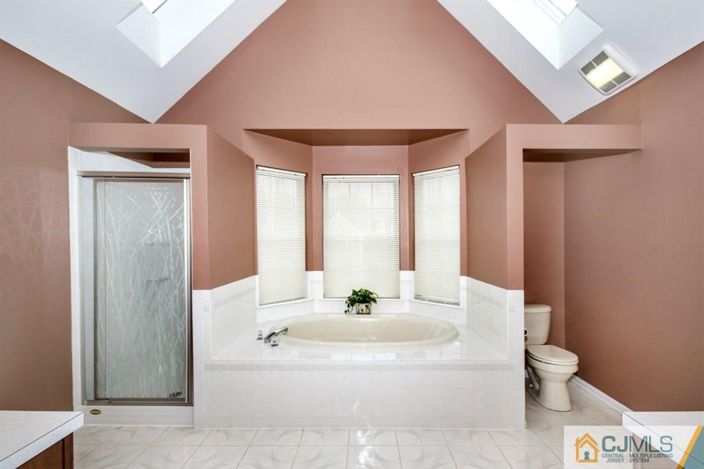 27 Timber Ridge Road North Brunswick, NJ 08902 - Photo 15 of 25 a white bath tub sitting in a bathroom next to a window