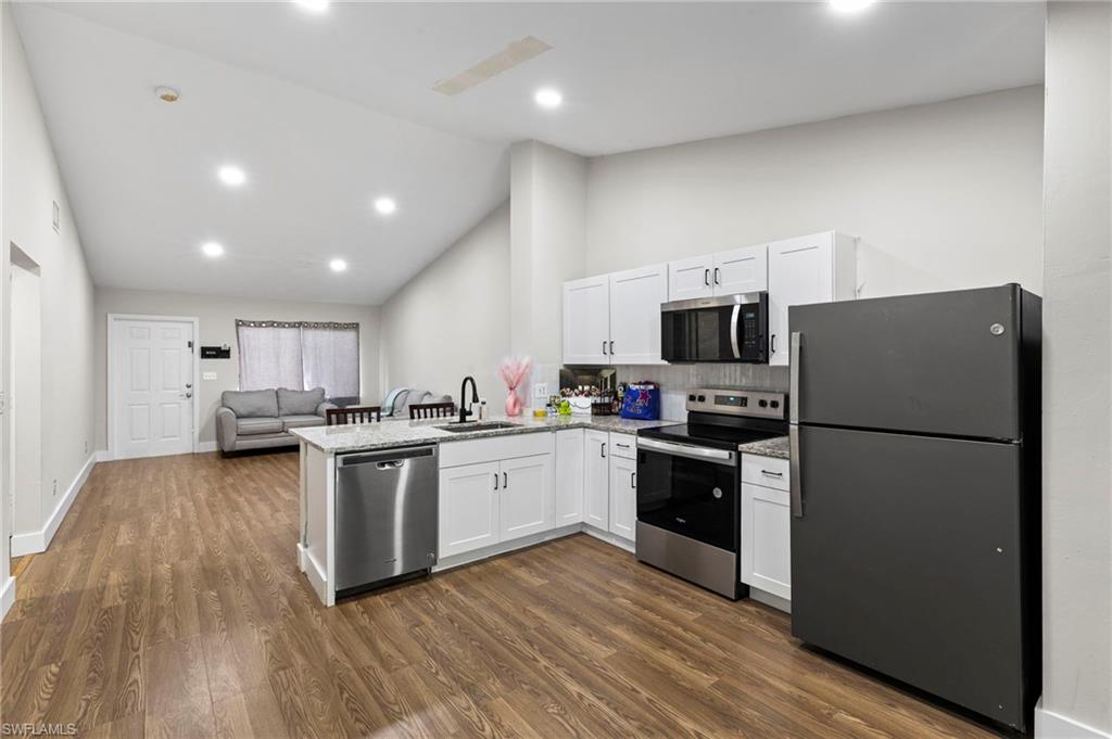 8264-8268 Matanzas Road Fort Myers, FL 33967 - Photo 21 of 33 a kitchen with a refrigerator microwave and stove top oven