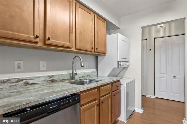 a kitchen with stainless steel appliances granite countertop a sink and cabinets with wooden floor