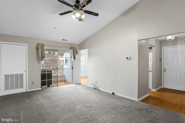 a view of a livingroom with a chandelier fan and windows