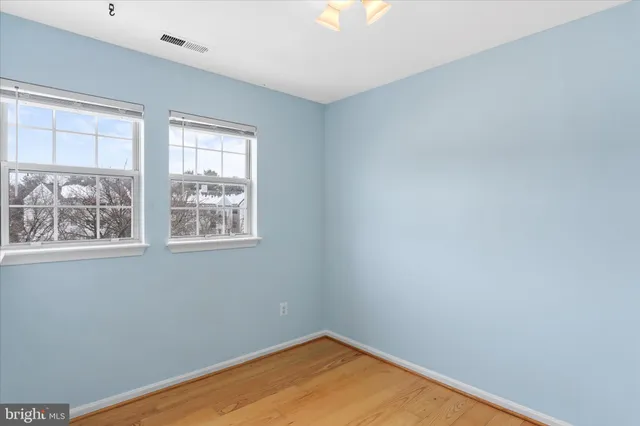 an empty room with wooden floor and closet