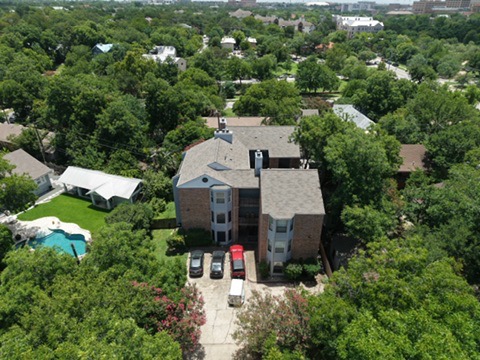 3011 Fruth Street, Unit 101 Austin, TX 78705 - Photo 13 of 14 An aerial perspective reveals a private pool nestled amidst mature trees, complementing the brick facade and expansive grounds.