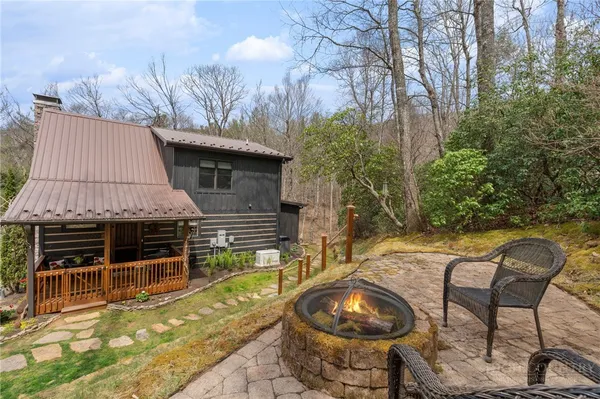 a backyard of a house with barbeque oven and outdoor seating