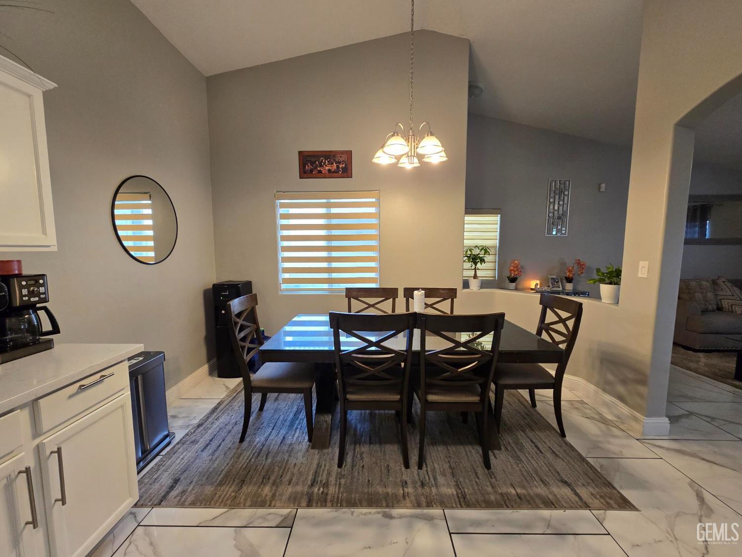 Undisclosed Address Bakersfield, CA 93307 - Photo 2 of 19 a view of a dining room and livingroom with furniture wooden floor a rug a fireplace and a chandelier
