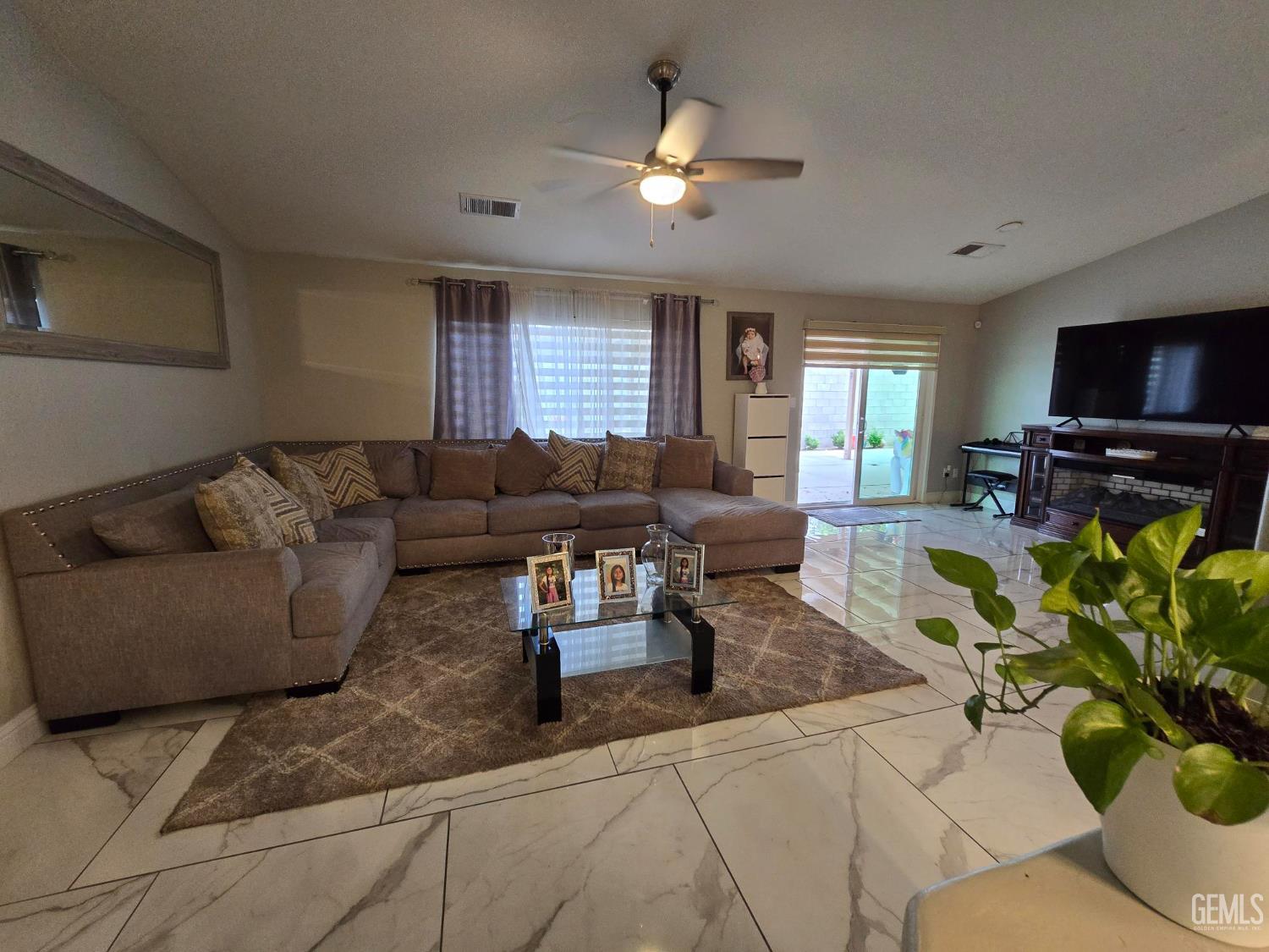 Undisclosed Address Bakersfield, CA 93307 - Photo 5 of 19 a living room with furniture a flat screen tv and a chandelier
