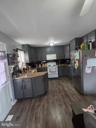 a kitchen with stainless steel appliances granite countertop a refrigerator sink and wooden cabinets