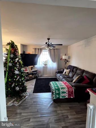 a living room with furniture hard wood floor and a fireplace