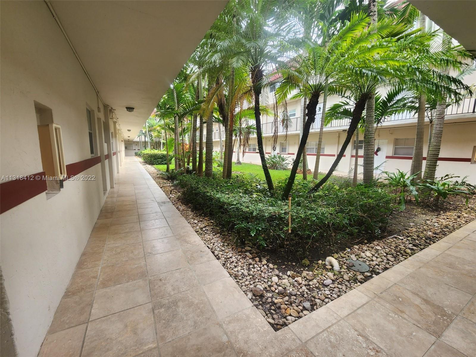 8600 Southwest 67th Avenue, Unit 906 Pinecrest, FL 33156 - Photo 2 of 27 a view of a pathway with a flower garden