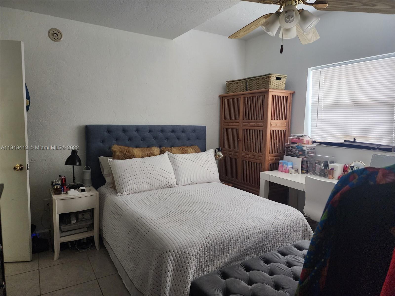 8600 Southwest 67th Avenue, Unit 906 Pinecrest, FL 33156 - Photo 22 of 27 a bedroom with a bed and a chandelier