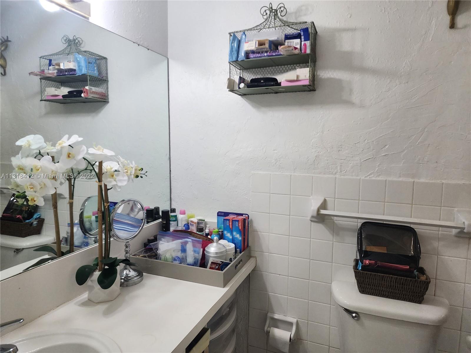 8600 Southwest 67th Avenue, Unit 906 Pinecrest, FL 33156 - Photo 26 of 27 a bathroom with a sink a toilet and a mirror