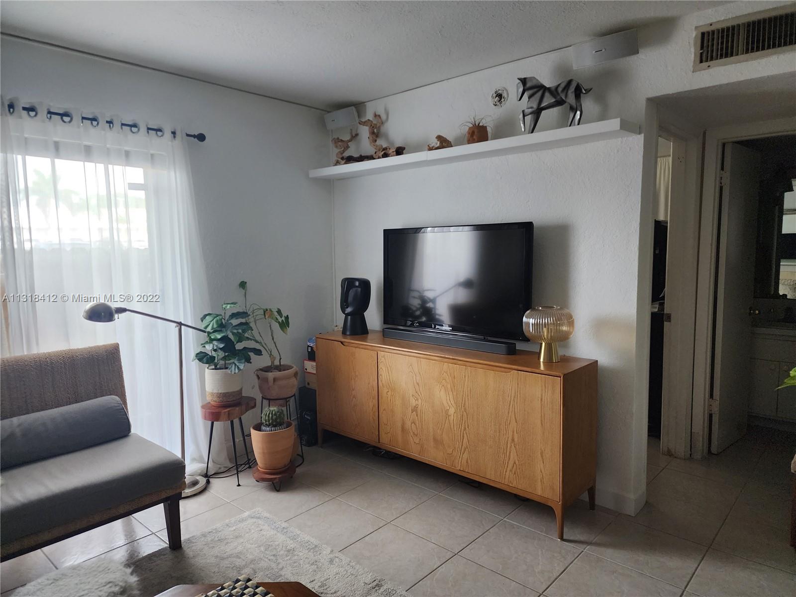 8600 Southwest 67th Avenue, Unit 906 Pinecrest, FL 33156 - Photo 6 of 27 a living room with furniture and a flat screen tv