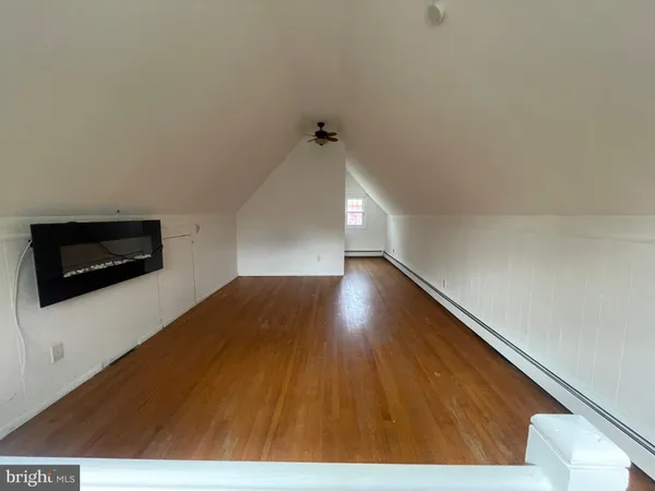 a view of a room with wooden floor and a ceiling fan