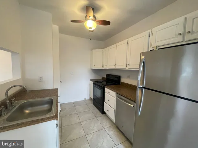 a kitchen with stainless steel appliances granite countertop a sink a stove a refrigerator a counter space and cabinets