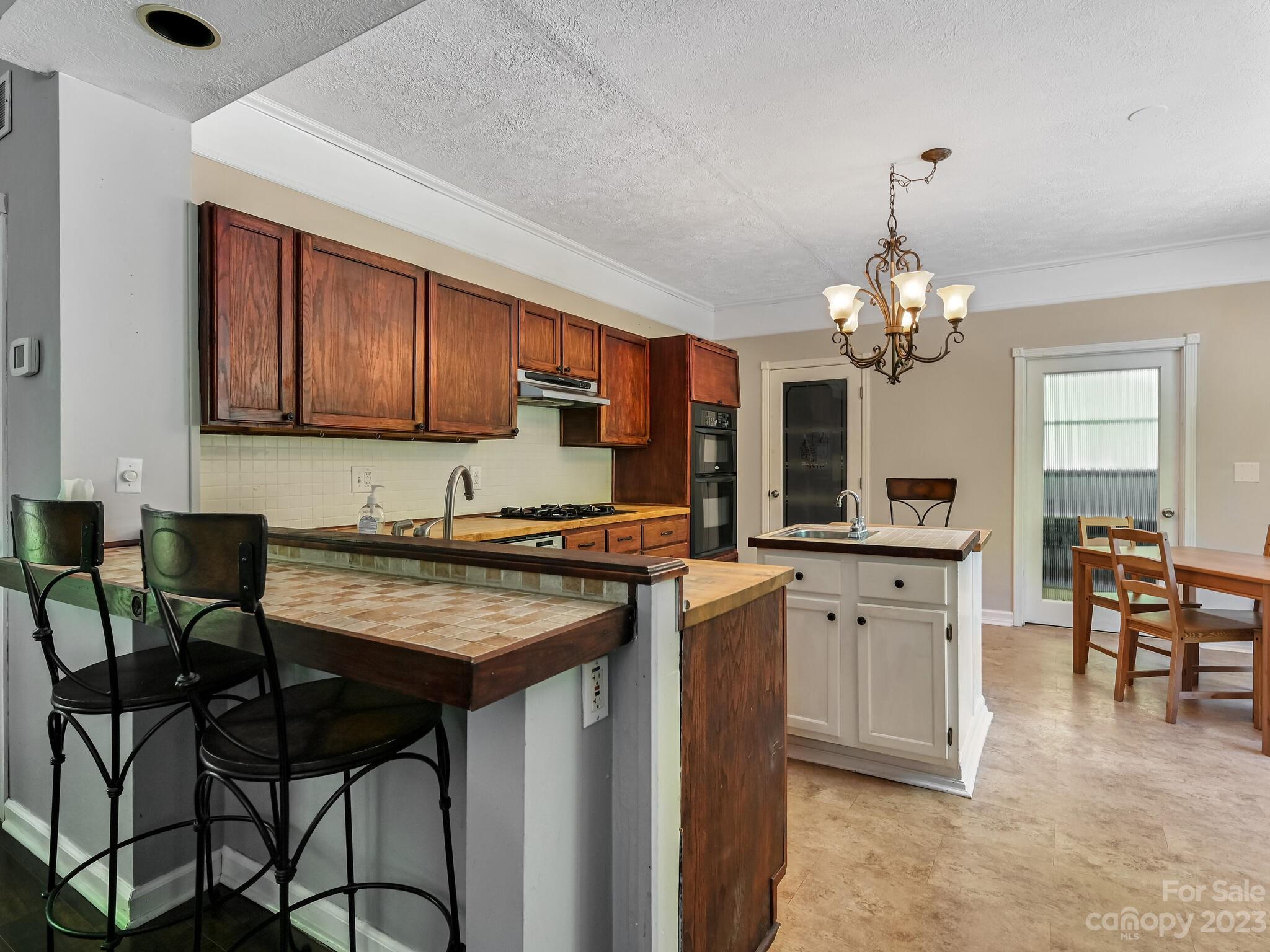 843 North Fork Road Barnardsville, NC 28709 - Photo 7 of 37 a kitchen with stainless steel appliances granite countertop a stove top oven a sink dishwasher a dining table and chairs with wooden floor
