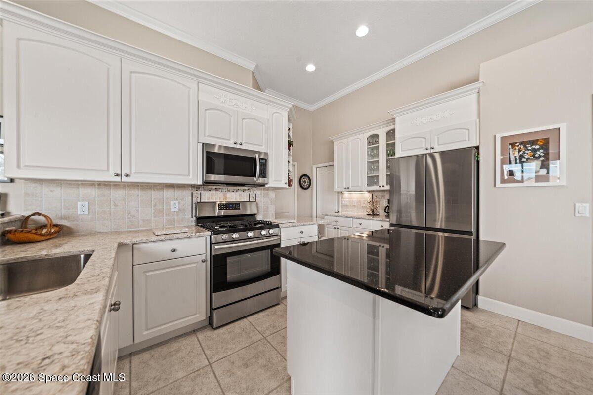 1050 Starling Way Rockledge, FL 32955 - Photo 12 of 59 a kitchen with granite countertop a sink stove and refrigerator