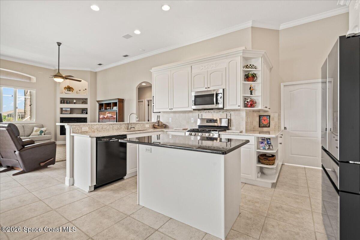 1050 Starling Way Rockledge, FL 32955 - Photo 14 of 59 a kitchen with stainless steel appliances granite countertop a stove top oven a refrigerator a sink and a refrigerator