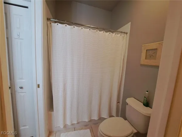 a white toilet sitting next to a shower curtain