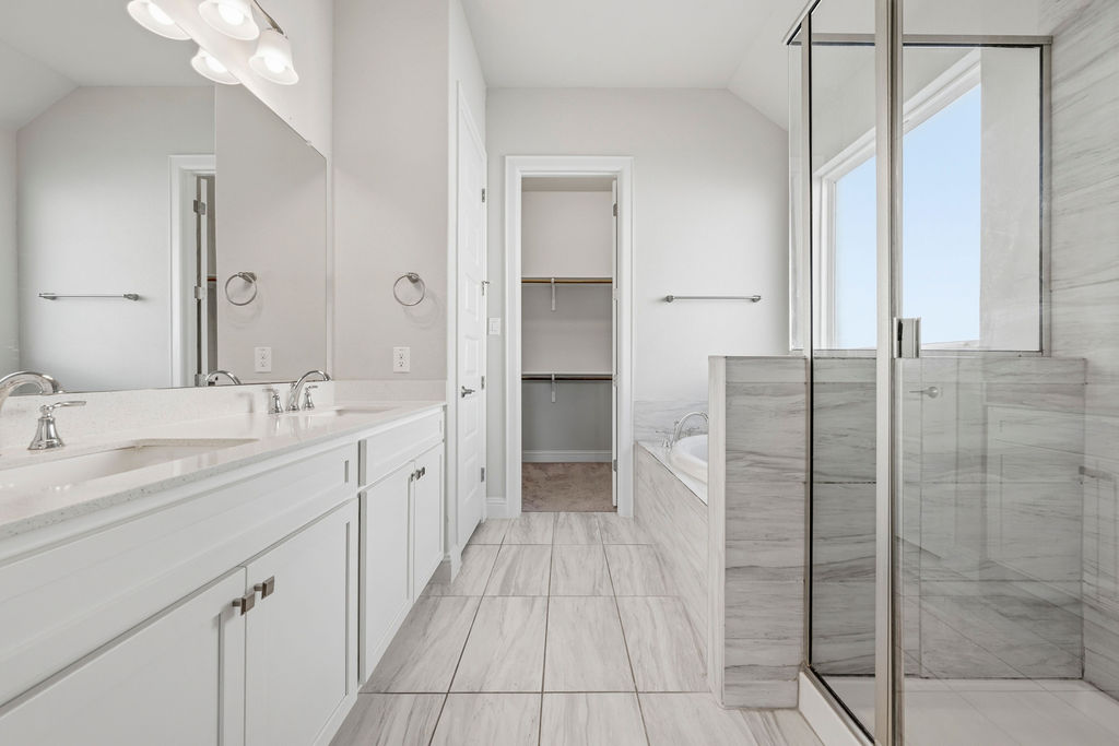 2032 Base Burner Path Leander, TX 78641 - Photo 25 of 34 Bathroom featuring a double vanity with stone countertops, a glass-enclosed shower, a built-in bathtub, tile flooring, and a walk-in closet with shelving