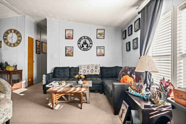a living room with furniture and paintings on the wall