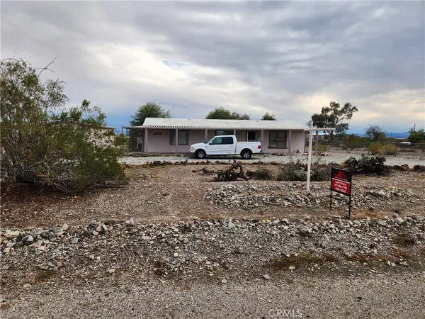 a view of house with a yard and table and chairs