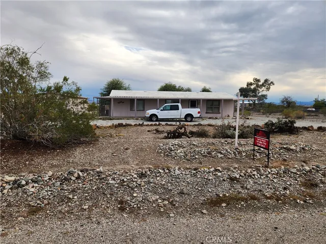 a view of house with a yard and table and chairs