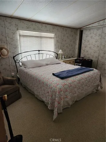 a bedroom with a bed and a mirror