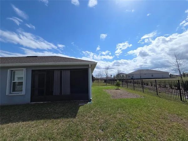 a view of a room with a chandelier windows and a wooden floor