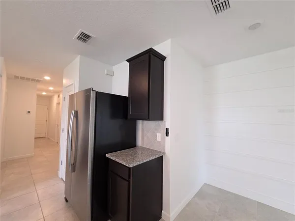 a kitchen with stainless steel appliances granite countertop a sink and a refrigerator