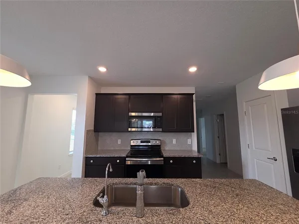 a kitchen with stainless steel appliances granite countertop a stove and a microwave