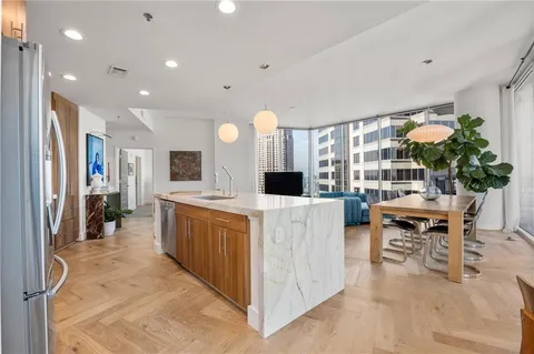 a view of a dining room and livingroom with furniture wooden floor a chandelier