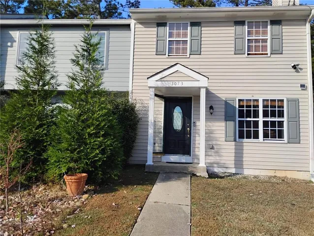a front view of a house with plants