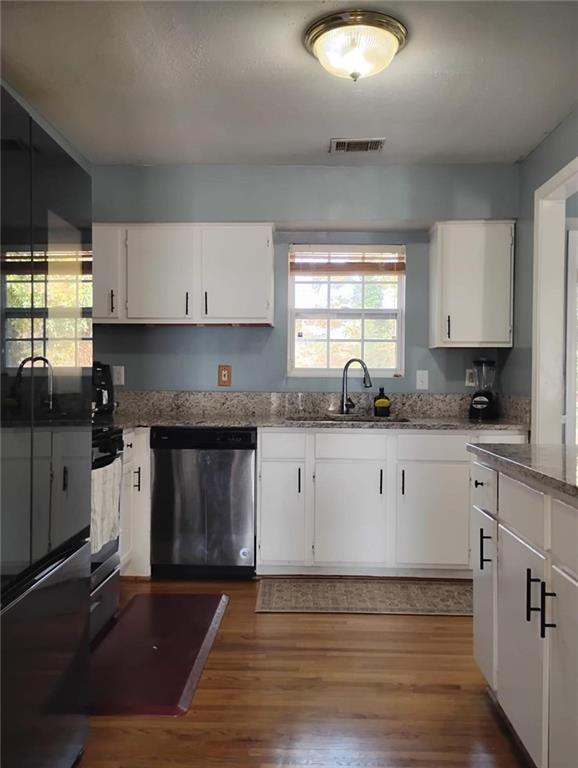 3073 Shadow Walk Lane Tucker, GA 30084 - Photo 7 of 48 a kitchen with granite countertop a stove a sink and white cabinets with wooden floor
