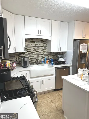a kitchen with granite countertop a sink stove and cabinets