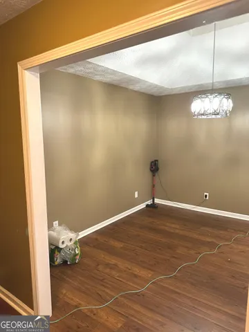 a view of a room with wooden floor and chandelier
