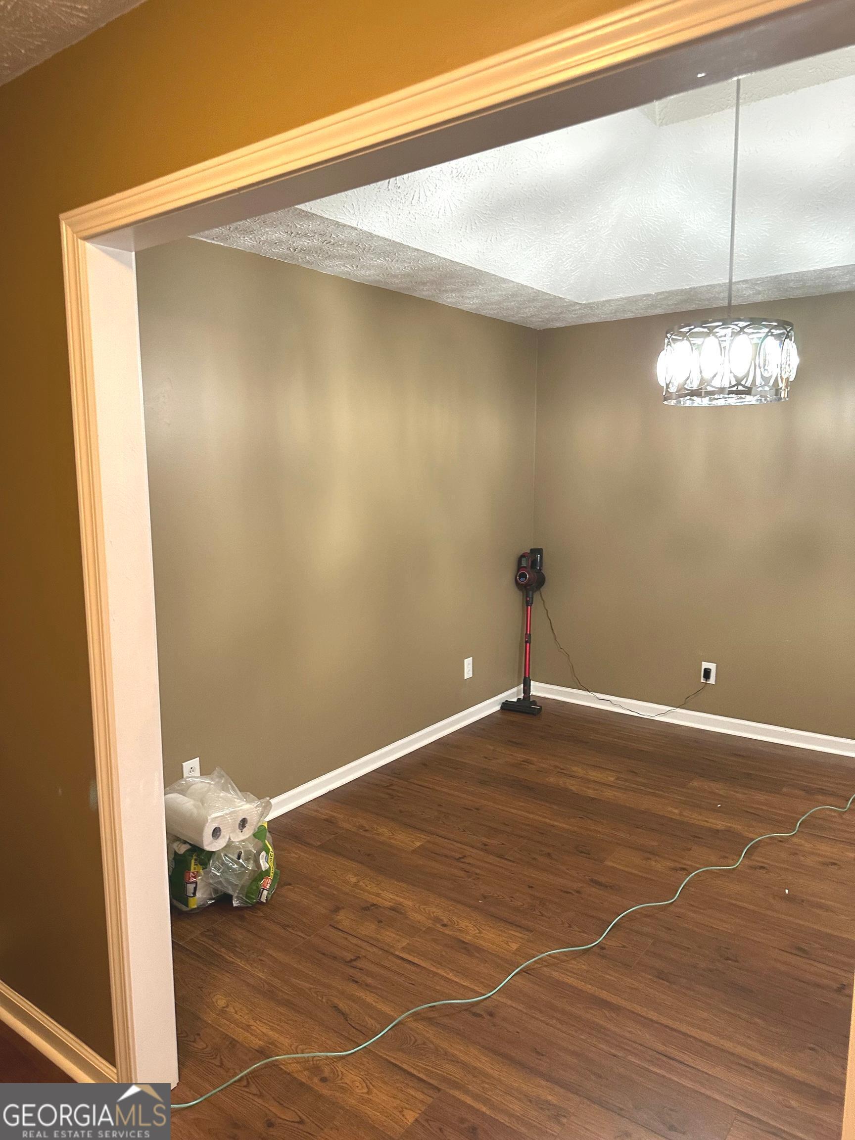 170 Ashley Trace Drive Locust Grove, GA 30248 - Photo 9 of 17 a view of a room with wooden floor and chandelier