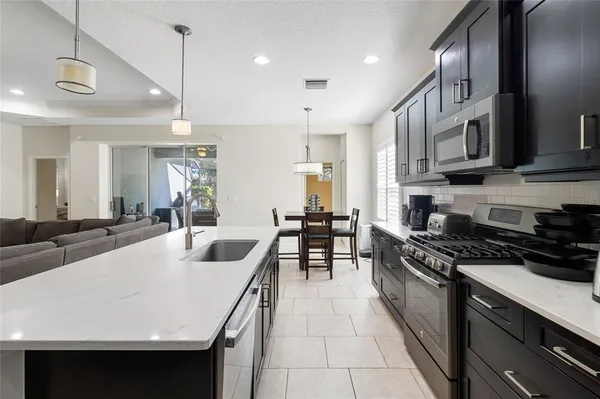 a large kitchen with stainless steel appliances a stove a sink a oven a counter space and a center island