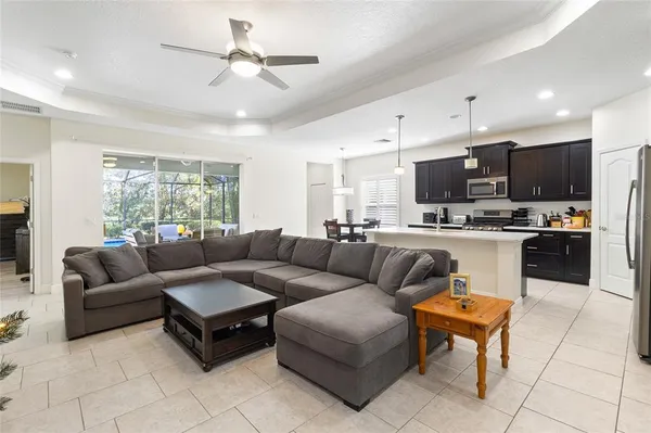 a living room filled with furniture and kitchen view