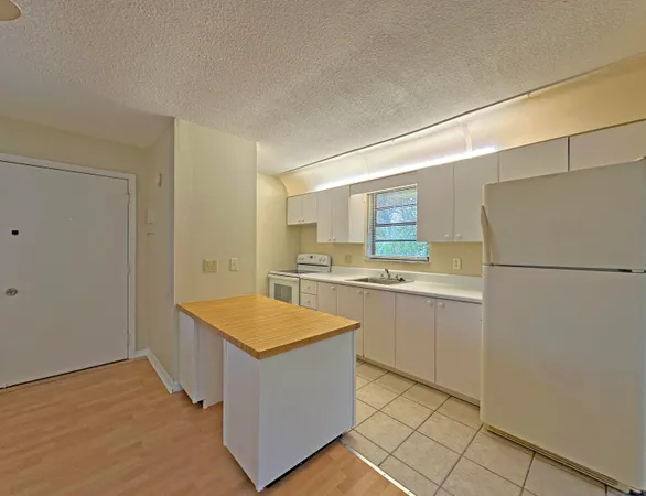 a kitchen with white cabinets and white appliances