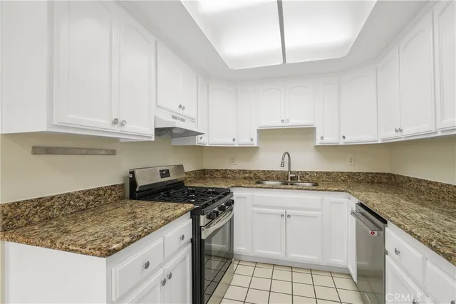 a kitchen with granite countertop white cabinets and white appliances