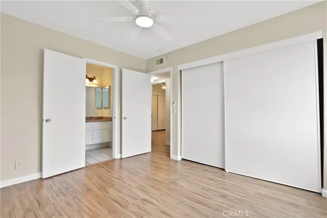 an empty room with wooden floor and closet area